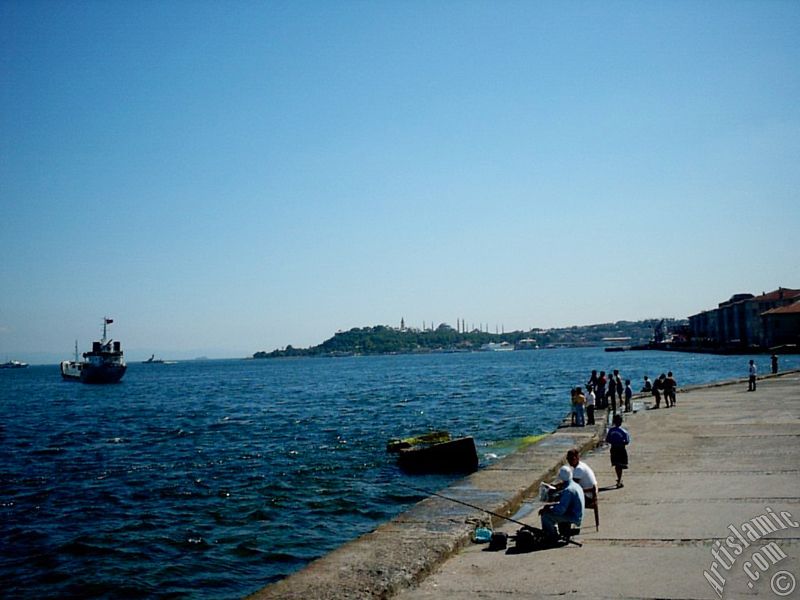 View of fishing people, Sarayburnu coast, Topkapi Palace, Ayasofya Mosque (Hagia Sophia) and Sultan Ahmet Mosque (Blue Mosque) from a park at Kabatas shore in Istanbul city of Turkey.
