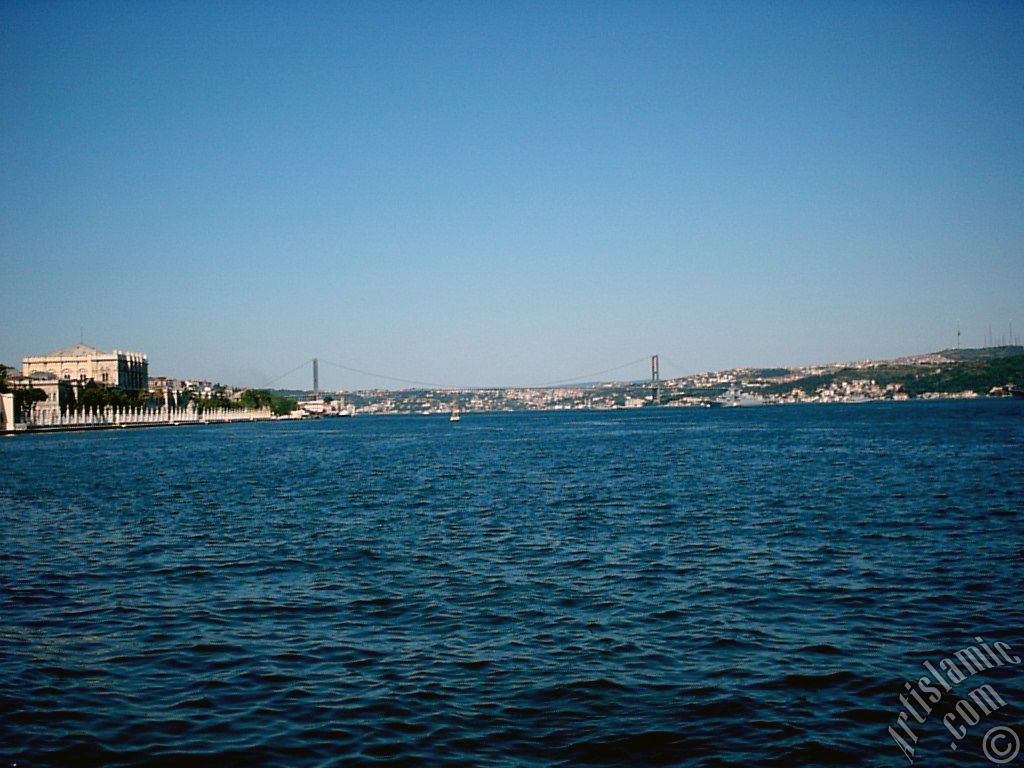 View of the Dolmabahce Palace, Bosphorus Bridge and Uskudar coast from a park at Dolmabahce shore in Istanbul city of Turkey.
