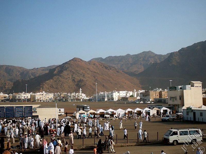 The Mounts Uhud, the field of Battle of Uhud (the second battle of the Prophet Muhammad [saaw] against unbelievers); the cemetery of the first muslims died for Islam during the Battle of Uhud (located in the left) and the pilgrims visiting these places in Mecca city of Saudi Arabia.
