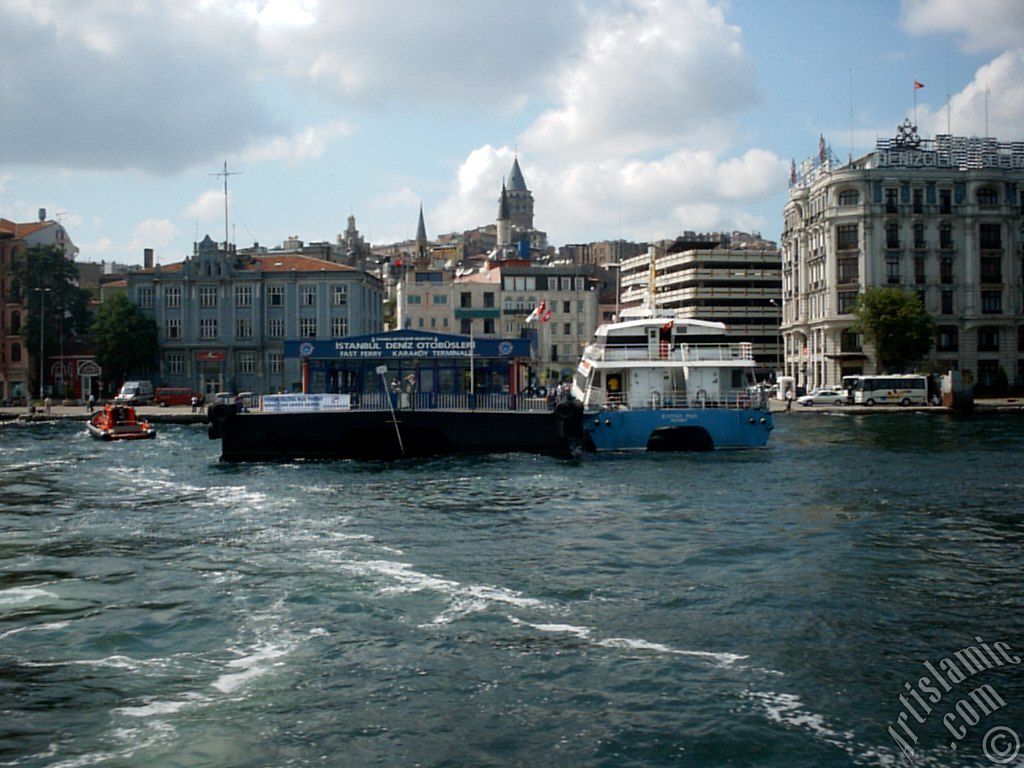 View of the sea bus landed the jetty and at behind above historical Galata Tower from the shore of Karakoy in Istanbul city of Turkey.
